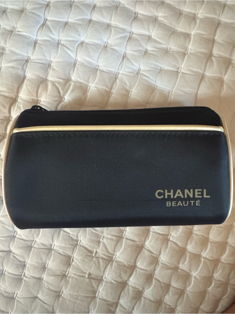CHANEL Beauté Black and Cream Makeup Pouch and skincare products.